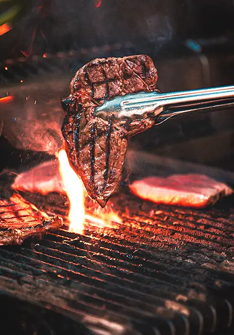 A delicious summer tradition on display, grilling burgers over an open fire.