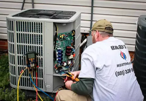 Brad McCulloch of Brad's Heating & Air diligently repairs an AC unit in Jacksonville AR
